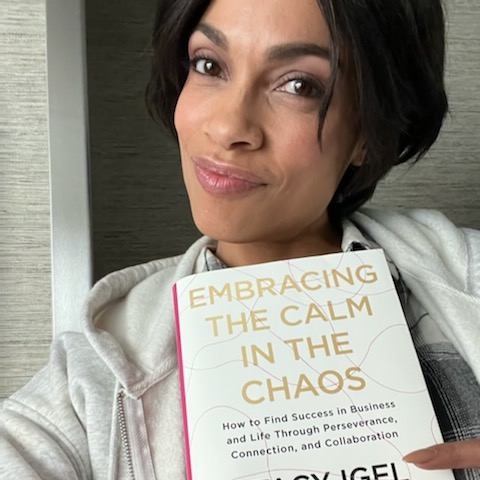 Rosario Dawson holding a hardcover of "Embracing the Calm in the Chaos"